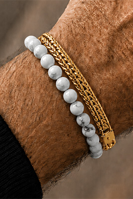 White marble bead bracelet paired with a gold mesh bracelet on a masculine wrist.