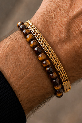 Brown Tiger Eye bead bracelet paired with a gold mesh bracelet on a masculine wrist.