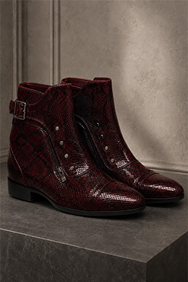 Snakeskin-style men's boots advertised in a sophisticated very dark burgundy color