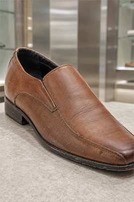 A quality leather shoe showing dust, dried leather, worn edges, loose stitching, and neglected creasing
